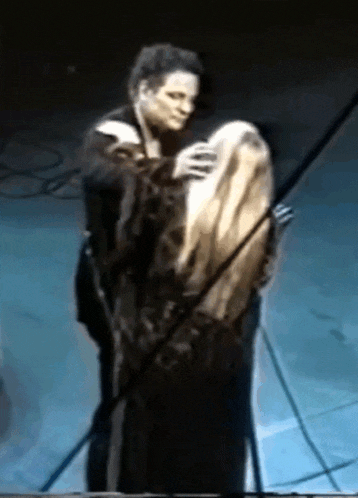 a man and woman are hugging on a stage