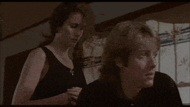 a man and a woman are standing next to each other in a room