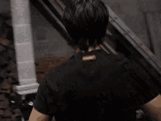 the back of a person wearing a black shirt with a red tag on the neck