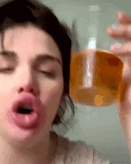 a close up of a woman holding a glass of beer