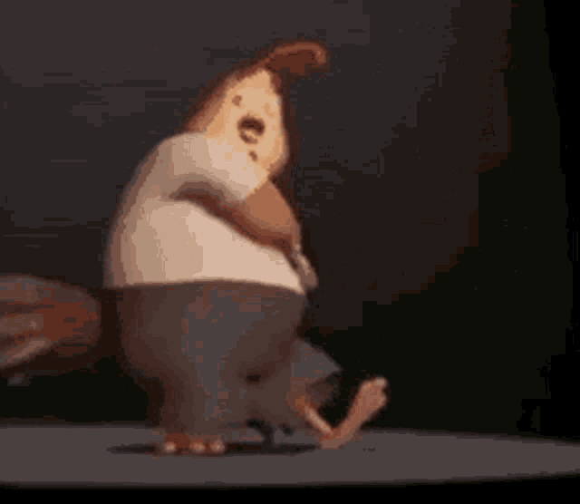a cartoon character is standing on a stage with his arms crossed and looking at the camera .