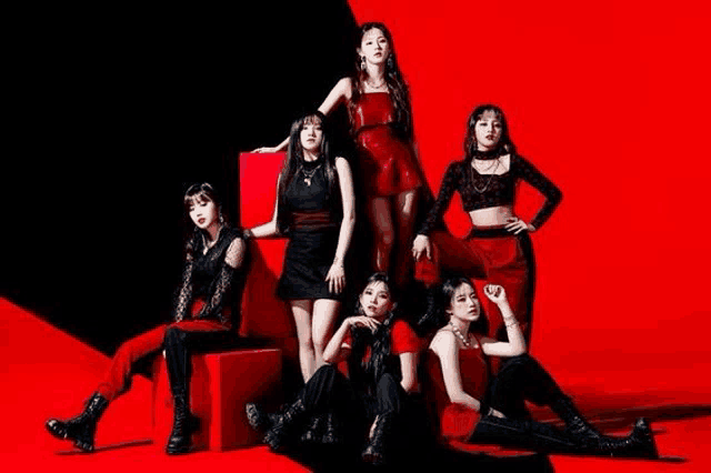 a group of girls are standing next to each other on a red and black background .