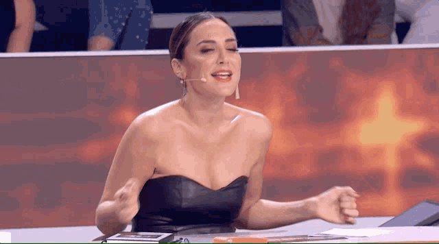 a woman in a black strapless top is sitting at a table