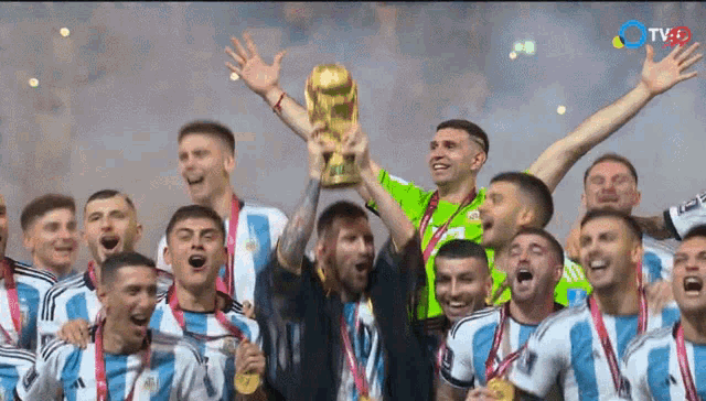 a group of soccer players are holding up a trophy with a tvgo logo in the background