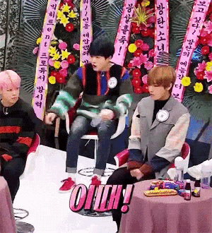a group of people sitting around a table with a sign that says oiih on it