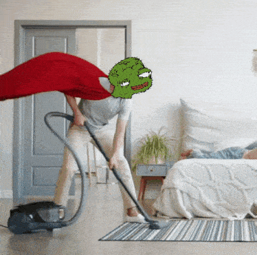 a man is using a vacuum cleaner in a bedroom with a frog on his head