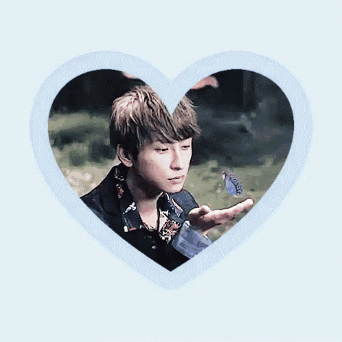 a man is holding a blue butterfly in his hand in a heart shaped frame