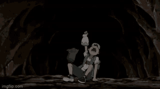 a boy is sitting on the ground in a cave holding a bottle .