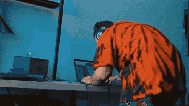 a man wearing headphones is using a laptop