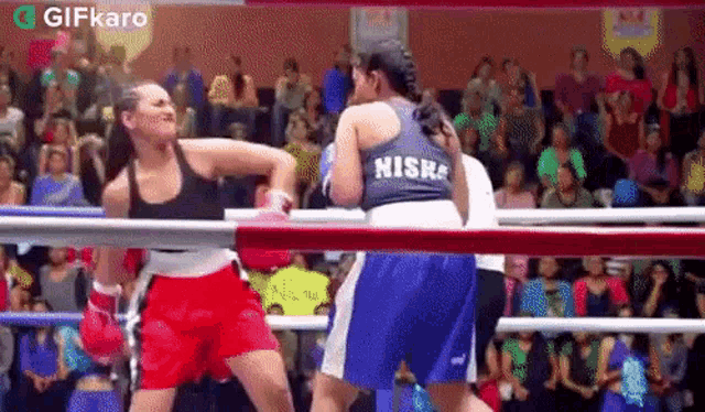 two women are boxing in a ring and one of them has the name nisra on her shirt