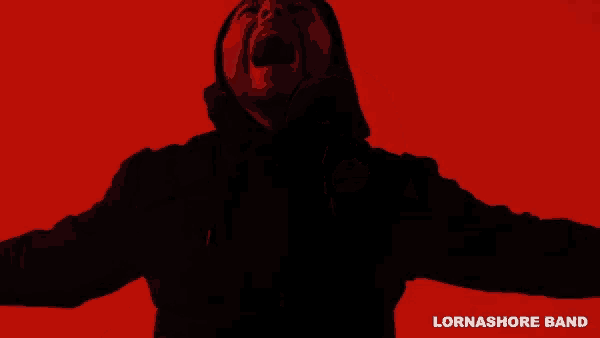 a man in a hooded jacket is screaming in front of a red background with lornashore band written below him