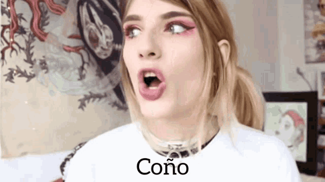 a woman wearing a white shirt with the word cono on the front