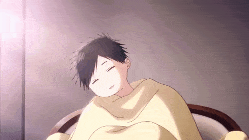a boy is sleeping on a bed wrapped in a blanket with his eyes closed .