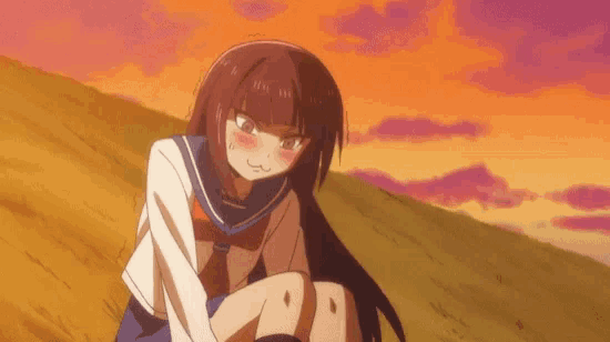 a girl in a sailor uniform is sitting on a hill .