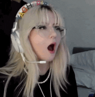 a girl with blonde hair and glasses is wearing headphones with a microphone .