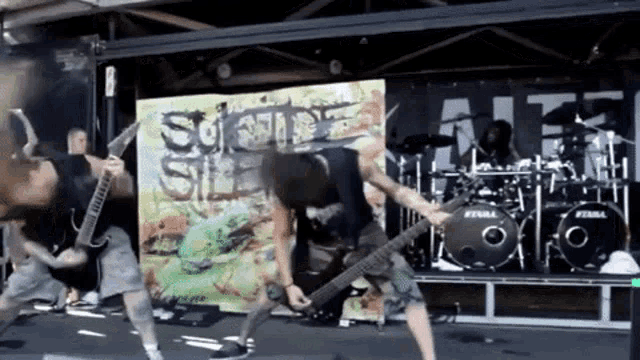 a man playing a guitar in front of a drum set that says ' stein ' on it