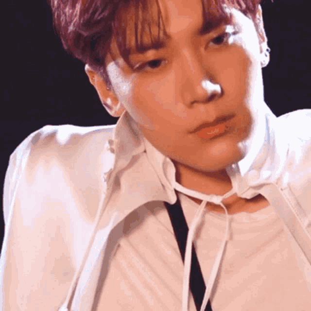 a close up of a man 's face with a white shirt and tie .