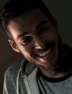 a man with a beard and mustache is smiling .