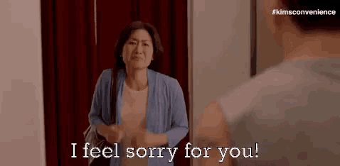a woman is talking to a man in a room and saying `` i feel sorry for you '' .
