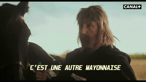a man holding a bottle of mayonnaise in front of a horse
