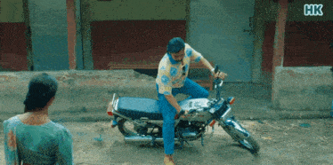 a man is sitting on a motorcycle with hk written on the bottom