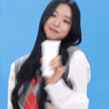 a woman with long black hair is holding a white bottle of lotion .