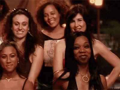 a group of women are posing for a picture together and smiling at the camera .