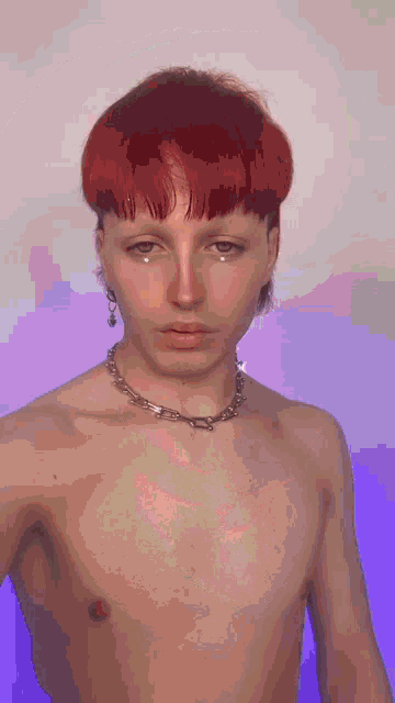 a shirtless man with red hair is wearing a necklace and earrings .