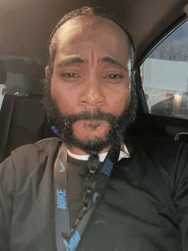 a man with a beard wearing a black nike shirt