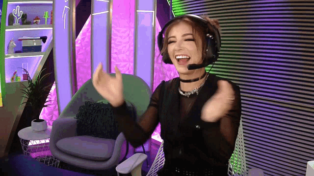a woman wearing headphones and a choker is sitting in front of a chair
