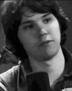 a close up of a man 's face with a microphone in front of him