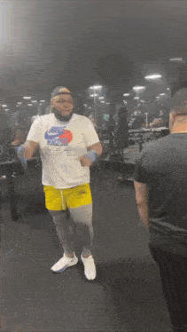 a man wearing a nike shirt is dancing in a gym .