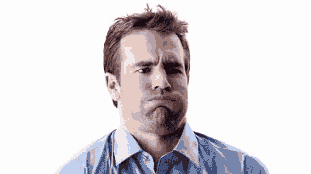 a man in a blue shirt is making a silly face