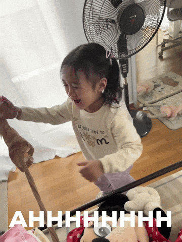 a little girl is crying in front of a fan and the words ahhhh are visible