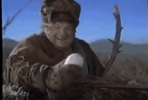 a man in a hat is holding a stick in his hand and smiling