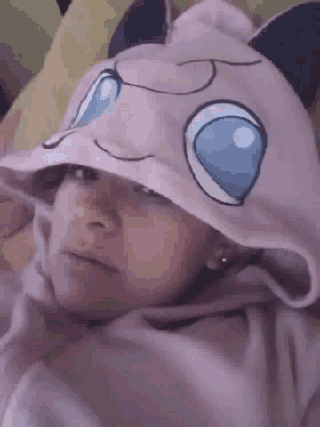 a woman wearing a pink hoodie with a cat face on it .
