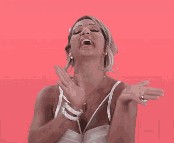 a woman in a white dress is making a funny face with her mouth open