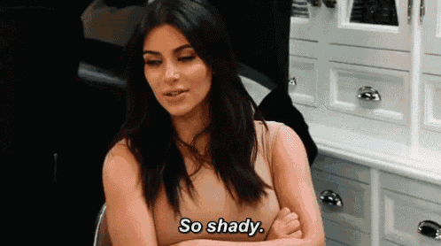 kim kardashian is sitting in a chair with her arms crossed and says so shady .
