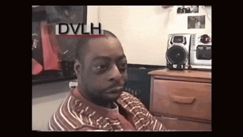 a man in a striped shirt is sitting in front of a speaker with the word dvlh on it .