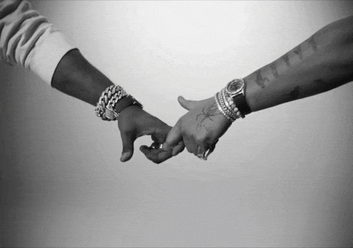 a black and white photo of a couple holding hands