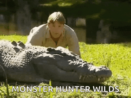 a man is crawling on top of a large crocodile in the grass .