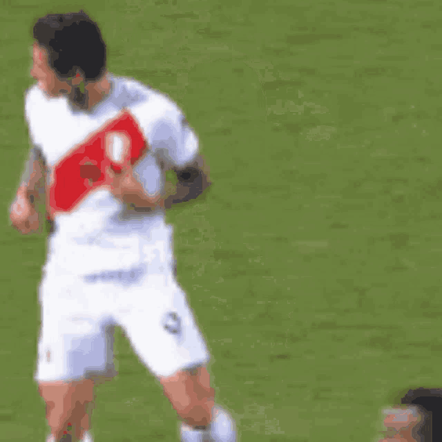 a soccer player in a white jersey with a red stripe on the back