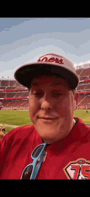 a man wearing a san francisco 49ers hat and a red shirt