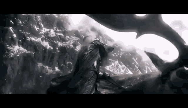 a man is riding a horse on top of a mountain while a shark is swimming in the water .