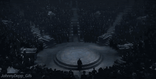 a man in a suit is standing in front of a crowd of people .