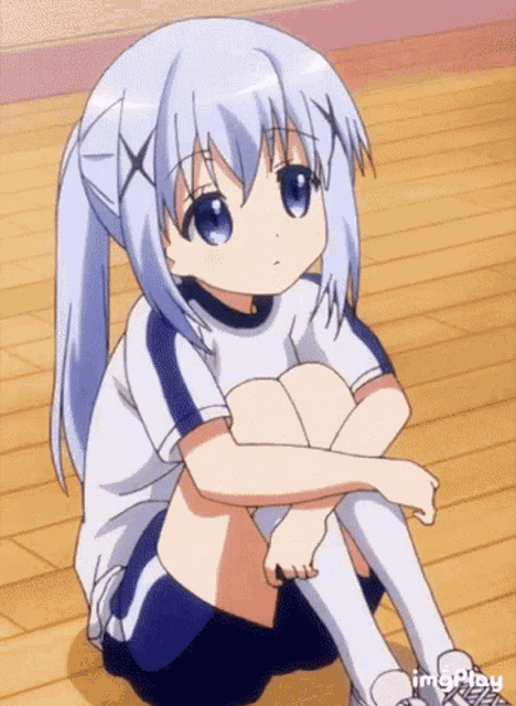 a girl with blue hair is sitting on the floor with her legs crossed ..