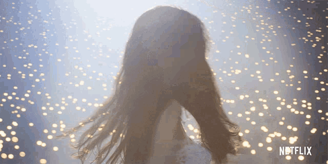 a woman with long hair is standing in front of a netflix ad