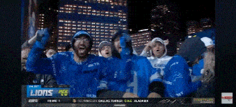 a group of people are watching a football game and one of them has the number 9 on their jersey