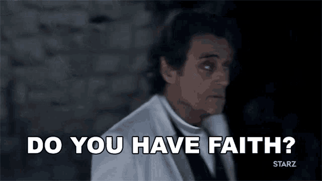 a man in a white suit is talking into a microphone and asking do you have faith .