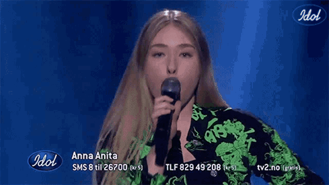 a woman singing into a microphone with the word idol on the bottom